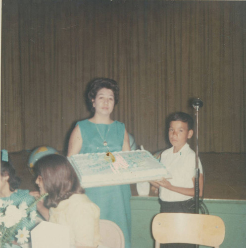 Joe Ramirez and mother display a sheet cake