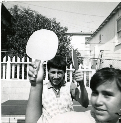 Martinez siblings playing table tennis, East Los Angeles, California