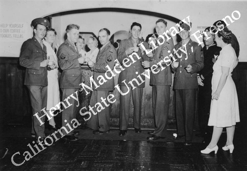 Eight men and five women posing in front of a coffee bar