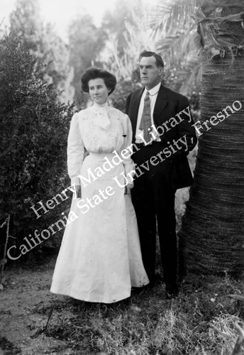 Man and woman next to palm tree