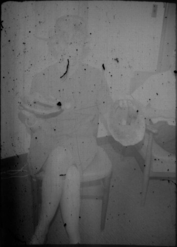 Unidentified woman seated in a chair, eating