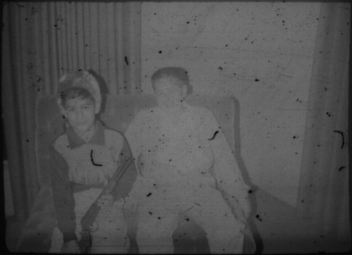 Two unidentified young men (Peters relatives?) in costumes seated on a couch