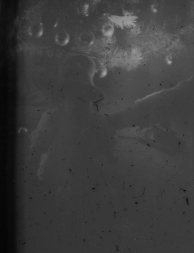 Unidentified child (Peters relative?) sitting in front of a Christmas tree