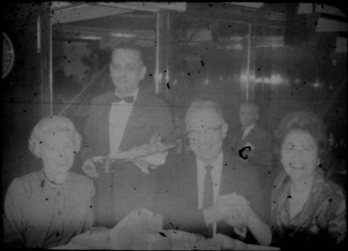 Alice Peters with waiter and unidentified man and woman at a restaurant