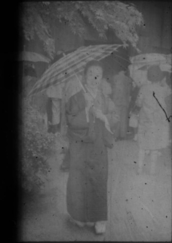 Woman in traditional Japanese clothing holding umbrella