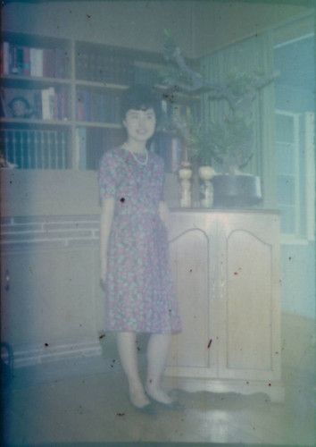 Unidentified woman standing next to cabinet