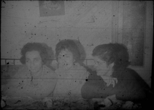 Three unidentified women seated at a table