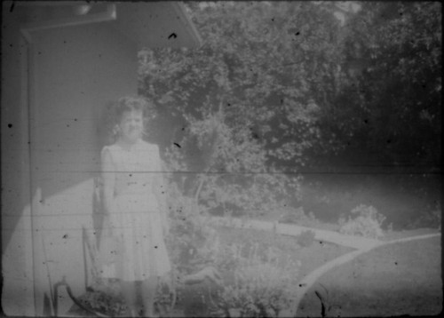 Unidentified woman standing in front of house