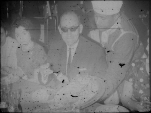 Waiter serving food to group of people in restaurant