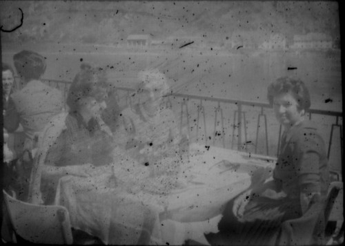 Alice Peters and two unidentified women seated at a cafe on a lake