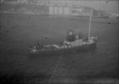 Tugboat guiding M/S Stella Polaris into harbor in unidentified city