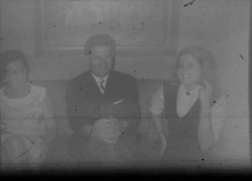 Two unidentified women and one unidentified man seated on a couch