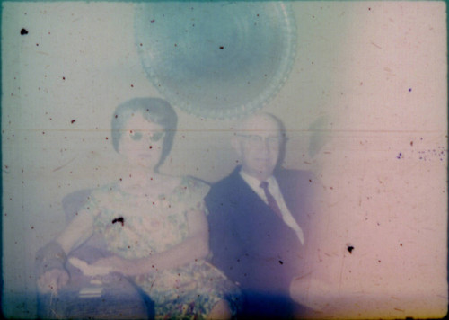 Unidentified man and woman seated on a couch