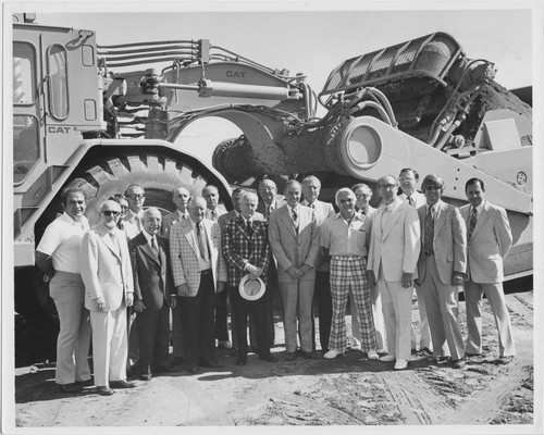 Group photo in front of construction equipment