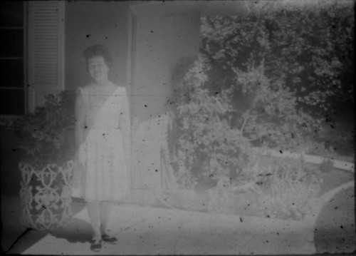 Unidentified woman standing in front of house