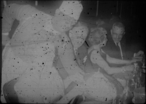 Waiter serving food to group of people in restaurant