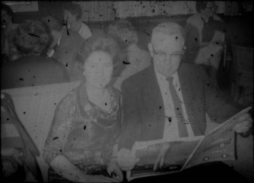 Alice Peters and unidentified man seated on bench