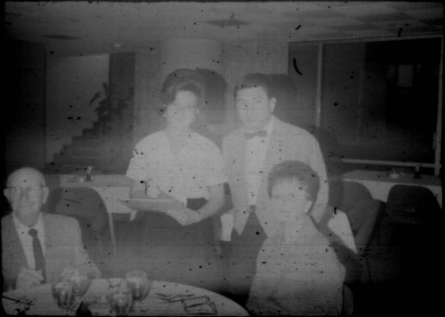 Group of unidentified people (Peters relatives?) gathered around a table