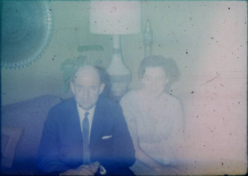 Unidentified man and woman seated on couches