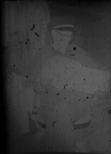 Unidentified man reading a newspaper in Myrtle Lake cabin