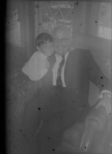 Unidentified man and boy seated in a chair