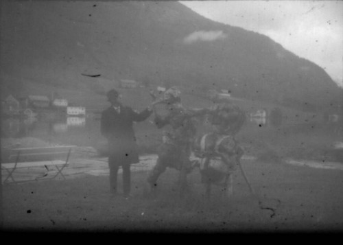 Unidentified man standing next to scarecrows