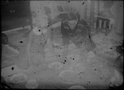 Unidentified man and woman eating a meal on a carpet