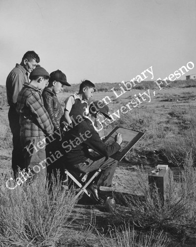 Artist completing a watercolor at Granada Relocation Center