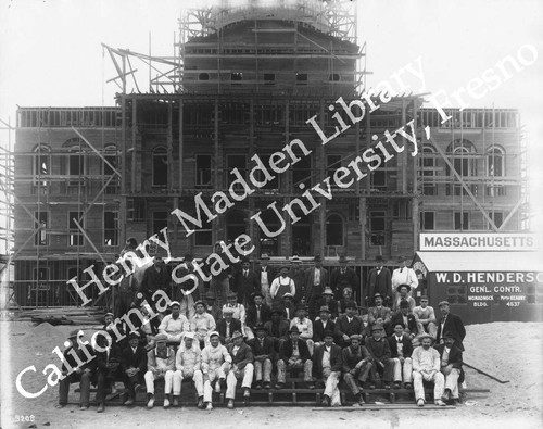 Front of Massachusetts State Building under construction and group of workmen in foreground