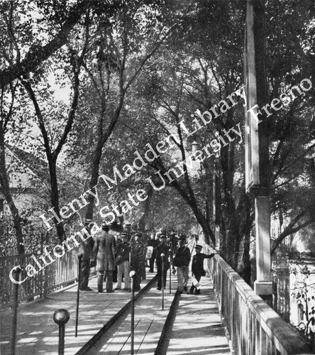 Fairgoers riding Rolling Sidewalk in the shade