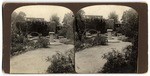 [View of garden walkway with pillar and bench]