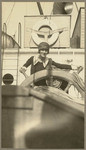 [Woman posing at ship's wheel on the Admiral Dewey]