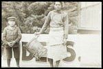 Samoan woman holding drum with young boy