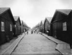 [Refugee children posing between rows of cottages. Camp 13, Franklin Square]