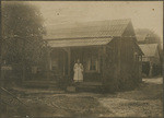 [Unidentified woman on porch of wood-frame house]