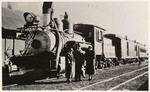 [Railroad locomotive and three people]