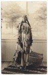 [American Indian woman standing next to basket]