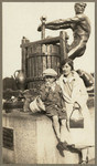 [Woman and boy seated at base of the Cider Press statue in Golden Gate Park]