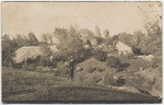 [Man holding rifle with mine buildings in background, Mariposa]