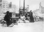 [Refugees with belongings in street]