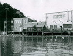 Waterfront view of backs of business houses on Main Street in Tiburon. Drugstore at left and Rossi's Bar in same group