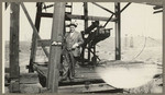 [Alfred Fuhrman standing at base of oil well]