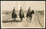 [Three soldiers on dirt road]