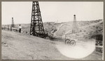 [Man and three oil wells]