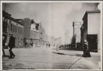 [Street scene of earthquake-damaged structures and fire in distance]