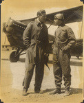 [Two pilots in front of biplane]