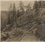 Rock quarry showing the clean exposure of rock and a portion of the grade to the dam before the track was laid. This picture was taken before the first big shot was fired, Aug. 2, 1913