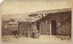 [Adobe house with woman sitting]