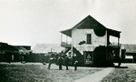 [Two-story adobe with wood balconies]