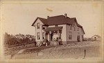 [People posed in front of Victorian house]